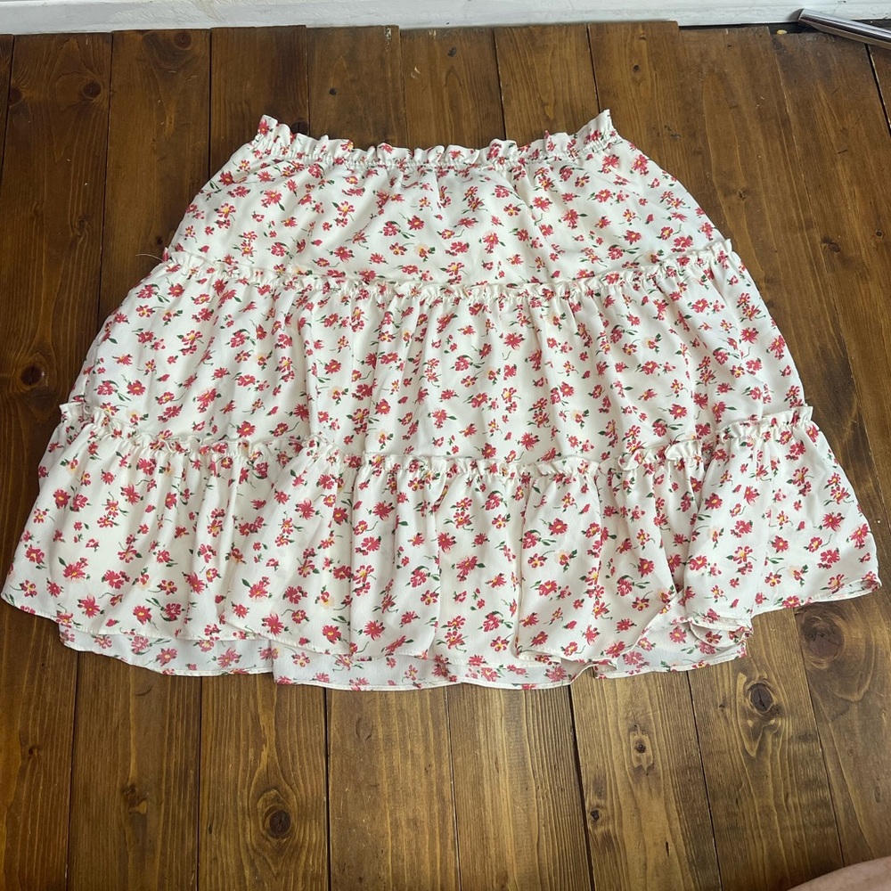Skies are blue short tiered skirt white with pink floral pattern size medium